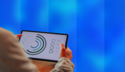 Main tenant une tablette affichant des indicateurs financiers : ventes, revenus, taxes et flux de trésorerie, représentant l’offre sur-mesure du cabinet Beloeuvre.