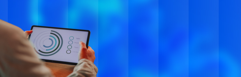 Main tenant une tablette affichant des indicateurs financiers : ventes, revenus, taxes et flux de trésorerie, représentant l’offre sur-mesure du cabinet Beloeuvre.