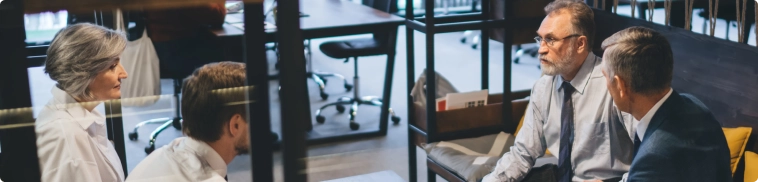 Discussion entre un expert-comptable et des clients dans un espace confidentiel, illustrant l’écoute et l’accompagnement personnalisé pour des demandes spécifiques.