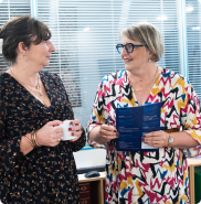 Deux collaborateurs échangent dans une ambiance professionnelle et chaleureuse.