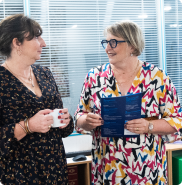 Deux collaborateurs échangent dans une ambiance professionnelle et chaleureuse.